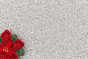 Red poinsettia with silver glitter paper background