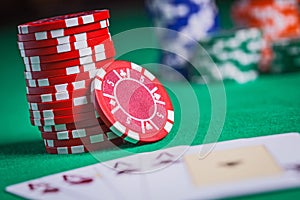 Red poker chips stacked on green table