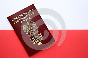 Red polish passport on smooth red and white flag of Poland
