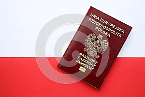 Red polish passport on smooth red and white flag of Poland