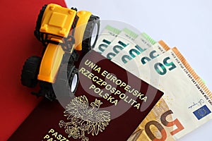Red polish passport and yellow tractor on euro money and smooth red and white flag of Poland