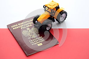 Red polish passport and yellow tractor on smooth red and white flag of Poland
