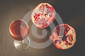 Red pomegranate juice in a glass/Ripe pomegranate, a piece and a glass of juice on a dark background, top view