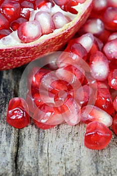 Red Pomegranate seeds on the wooden background