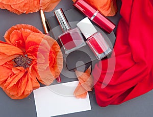 Red poppies and cosmetics red color - nail polish, lipstick and white business card mockup