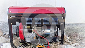 Red portable electricity generator on the street near house photo