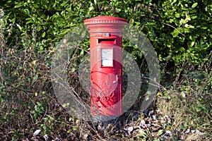 Red post box in rural countryside in England