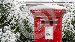 Red post box in the snow at Christmas