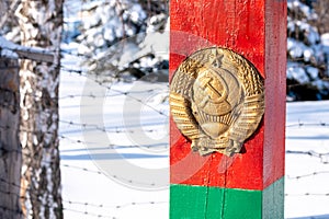 Red post with the emblem of the USSR stands on the border