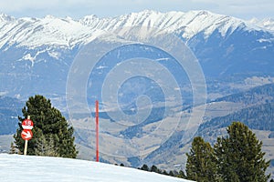Red post sign marking the edge of ski slope