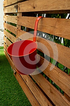 Red Pot Hanging on a Wooden Pallet Background