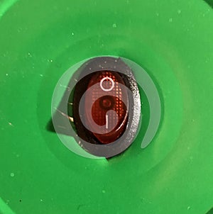 red power button on green background with shadow