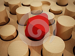 Red prism wooden block standing out among wooden cylinders. 3D illustration photo