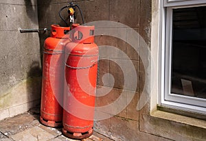 Red propane cylinders outside a house