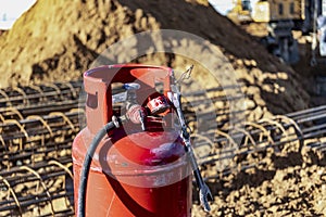 Red propane tank at a construction site. Equipment for gas cutting of metal. Metal processing at the construction site