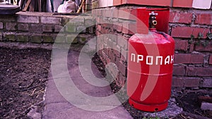 red propane tank lying on the ground