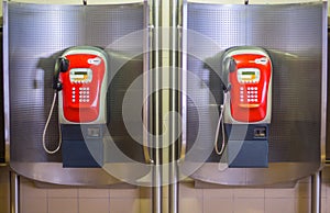 Red public telephone two booth on subway station.