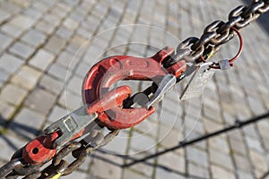 The red pulley connects and tightens the chain. There is a sidewalk under the pulley