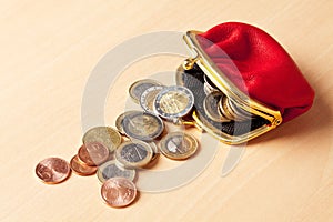 Red purse filled with euro coins