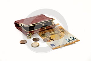 A red purse lying on fifty euro notes and coins, isolated