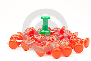 Red push pins with a green push pin standing out