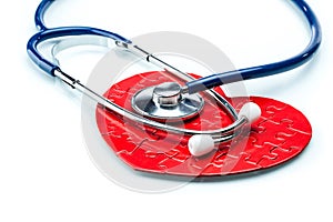 Red puzzle heart with stethoscope isolated on white background