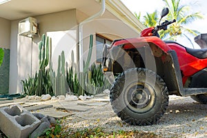 Red quad bike parked by a house