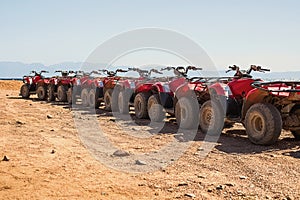 Red quads stand in a row on the shore of the Red Sea. Dahab, Egypt.