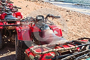 Red quads stand in a row on the shore of the Red Sea. Dahab, Egypt.