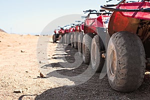 Red quads stand in a row on the shore of the Red Sea. Dahab, Egypt.