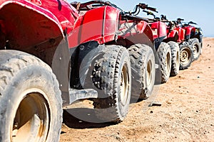 Red quads stand in a row on the shore of the Red Sea. Dahab, Egypt.