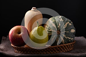 Red apple, pear and butternut squash in basket
