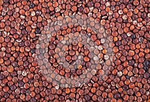 Red quinoa seeds background. Pile of raw kinwa. Top view.