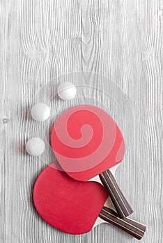 Red racket for ping pong ball wooden background top view