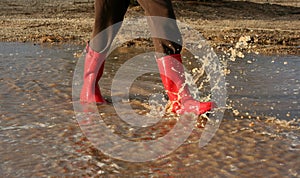 Red rain boots in puddle