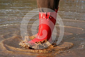 Red rain boots in puddle