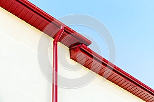 Red rain gutter system on rooftop