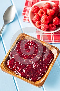 Red rasberries jam in bowl and ripe raspberries