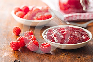 Red rasberries jam in bowl and ripe raspberries