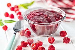 Red rasberries jam in bowl and ripe raspberries