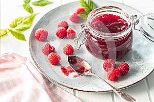 Red rasberries jam in jar and ripe raspberries