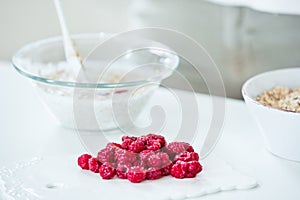 Red raspberries, muesli bowl in the background