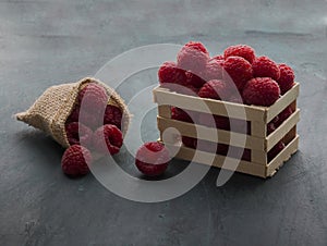Red raspberries placed on a small wooden fence and jute bag photo
