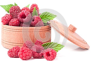 Red raspberries in a wooden bowl isolated on white background