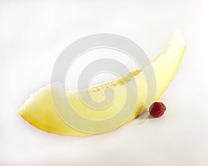 Red raspberries and yellow melon, white background. Vegetarian, diet food, photo