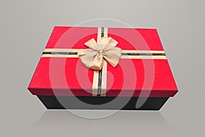 A red rectangular gift box with gold bow