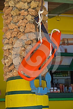 Red rescue board on a pillar at the beach bar