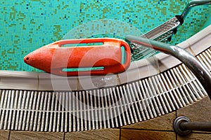 Red rescue buoy near the stairs in the swimming pool