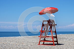 Red rescue tower and beach umbrella