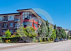 Red residential building on a street corner with cars parked beside